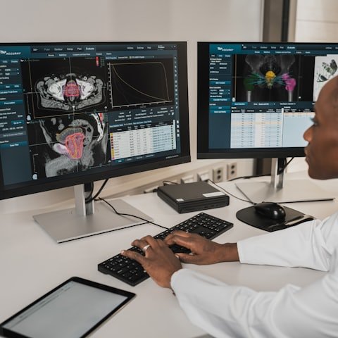Coding specialist entering charges at a dual-monitor workstation